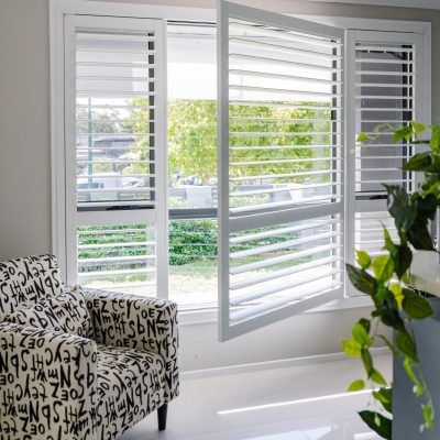 Open white plantation shutter window with sunlight filtering through, by Australian Plantation Shutters.