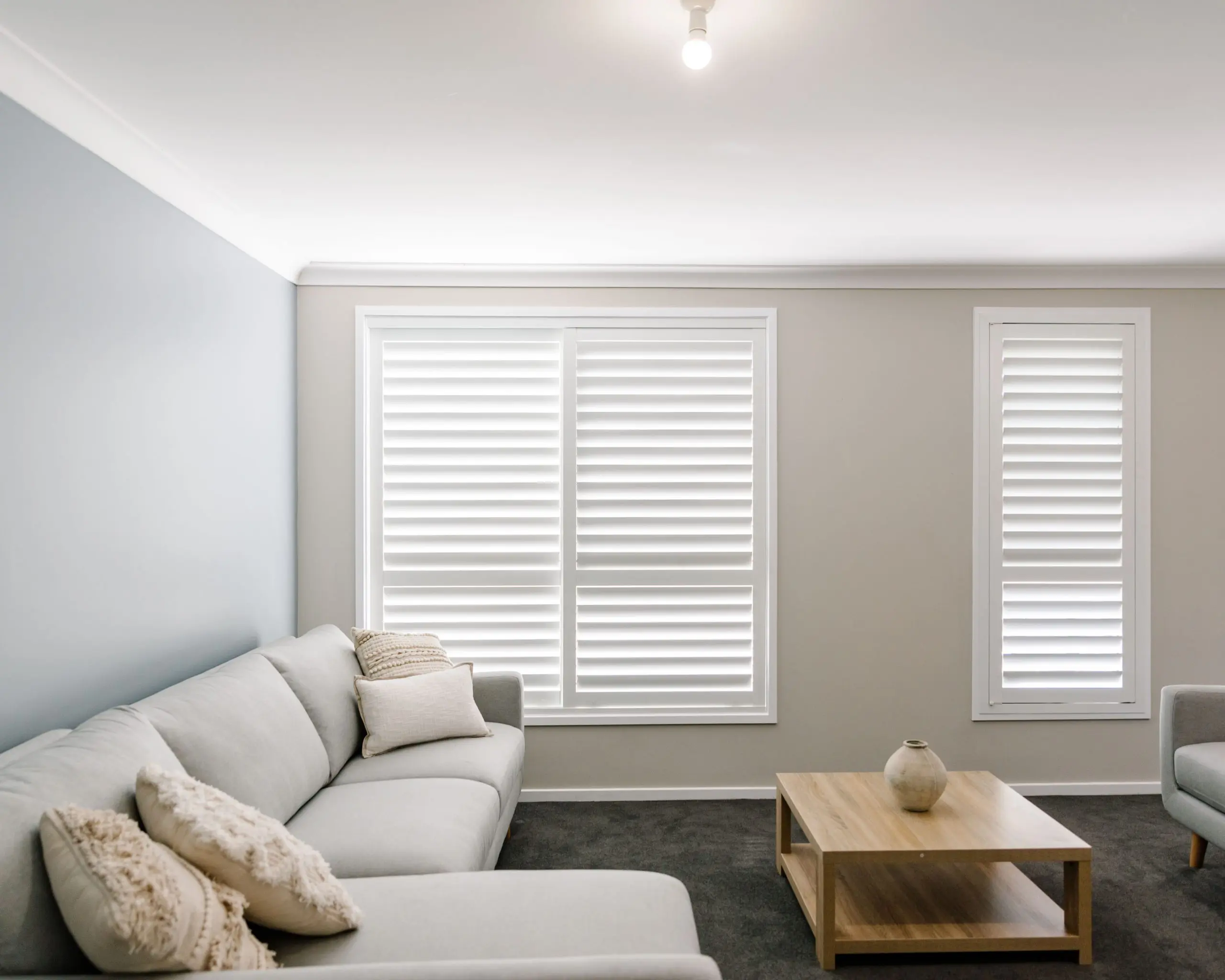 Modern living room with white plantation window shutters installed by Australian Plantation Shutters