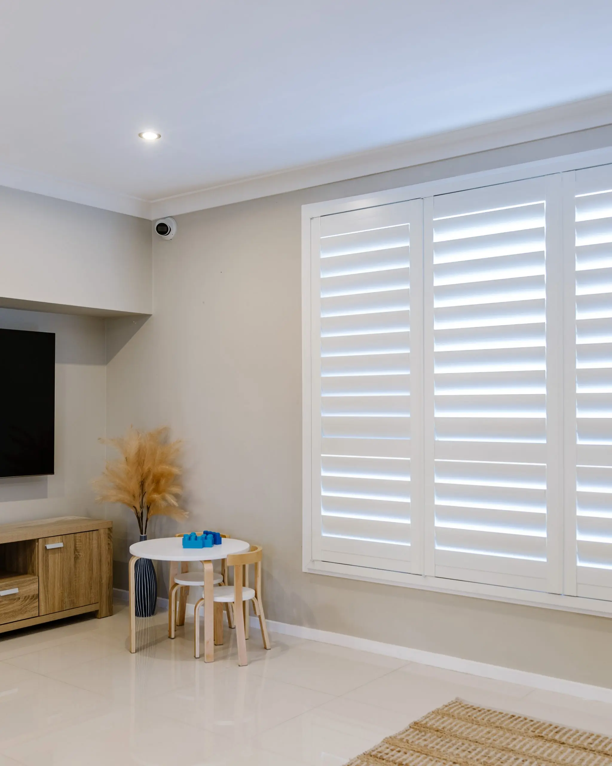 Modern living room with large white plantation window shutters installed by Australian Plantation Shutters