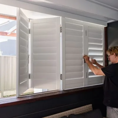 Technician installing Blifold open white plantation shutters designed by Australian Plantation Shutters