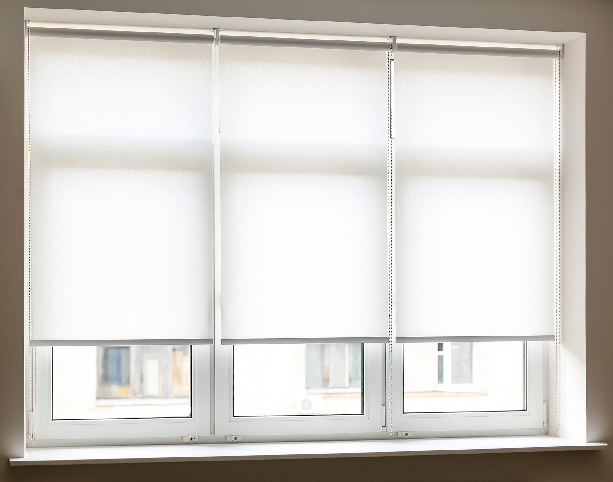 Three White Roller Blinds on a Window installed by Australian Plantation Shutters